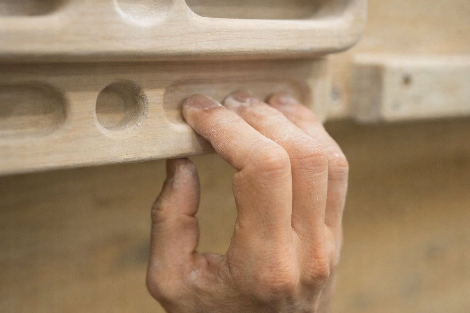 Nahaufnahme der Hand eines Kletterers am Hangboard bei einer Einheit für die Fingerkraft.