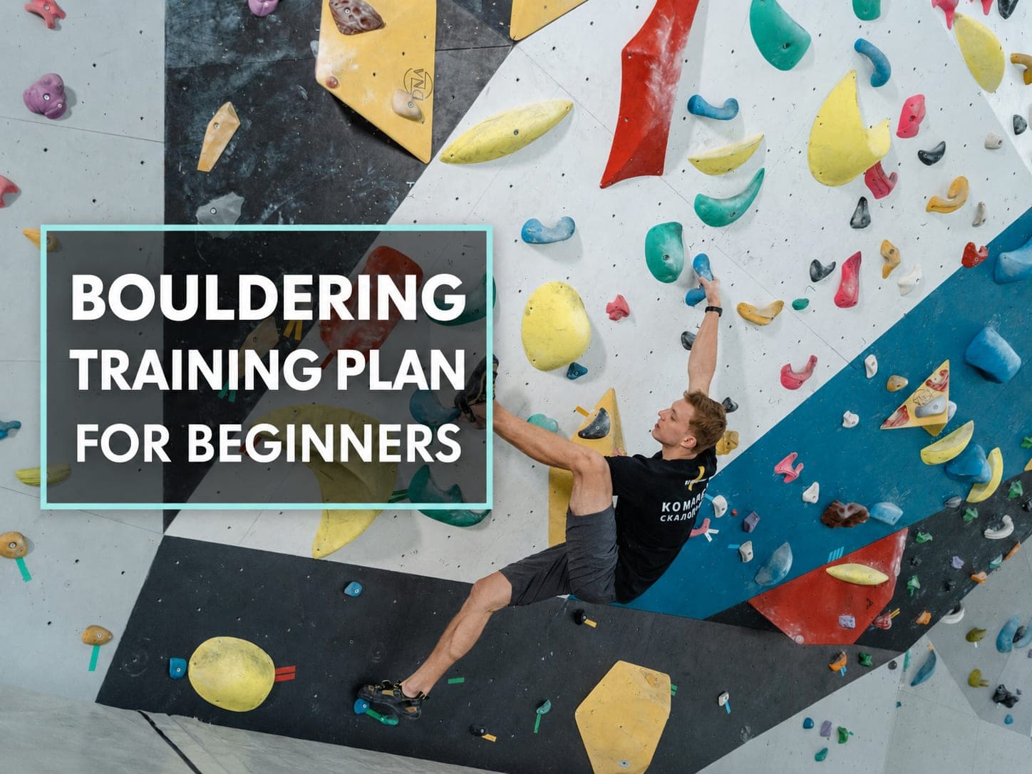 Ein Anfänger probiert einen Boulder an der Wand einer Boulderhalle.
